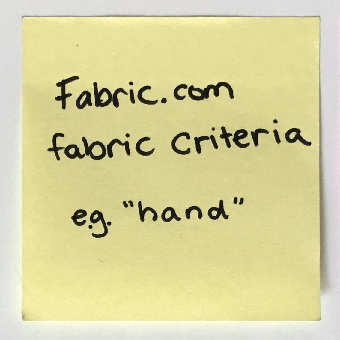 Post It with writing: 'Fabric.com fabric criteria e.g. hand'